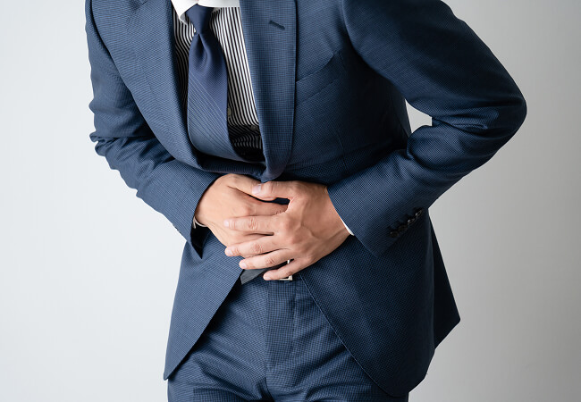お腹をおさえている男性